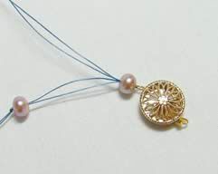 Two beads and a clasp strung onto a thread